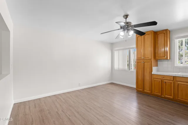 a view of a livingroom with wooden floor and a ceiling fan