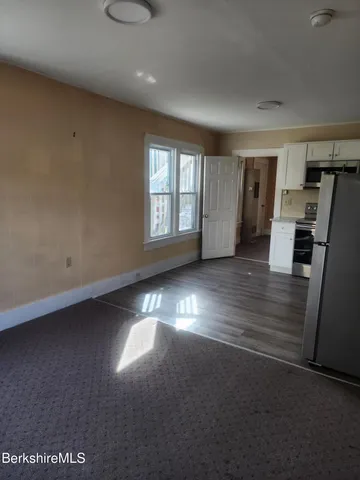 en empty room with windows and wooden floor