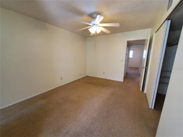 an empty room with a chandelier fan