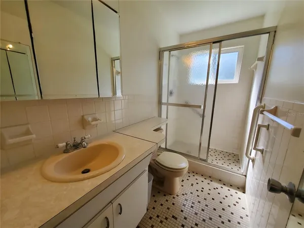 a bathroom with a sink toilet a mirror and shower