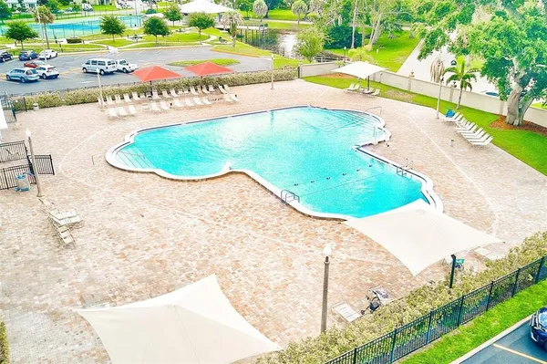 a view of a swimming pool with a yard and plants