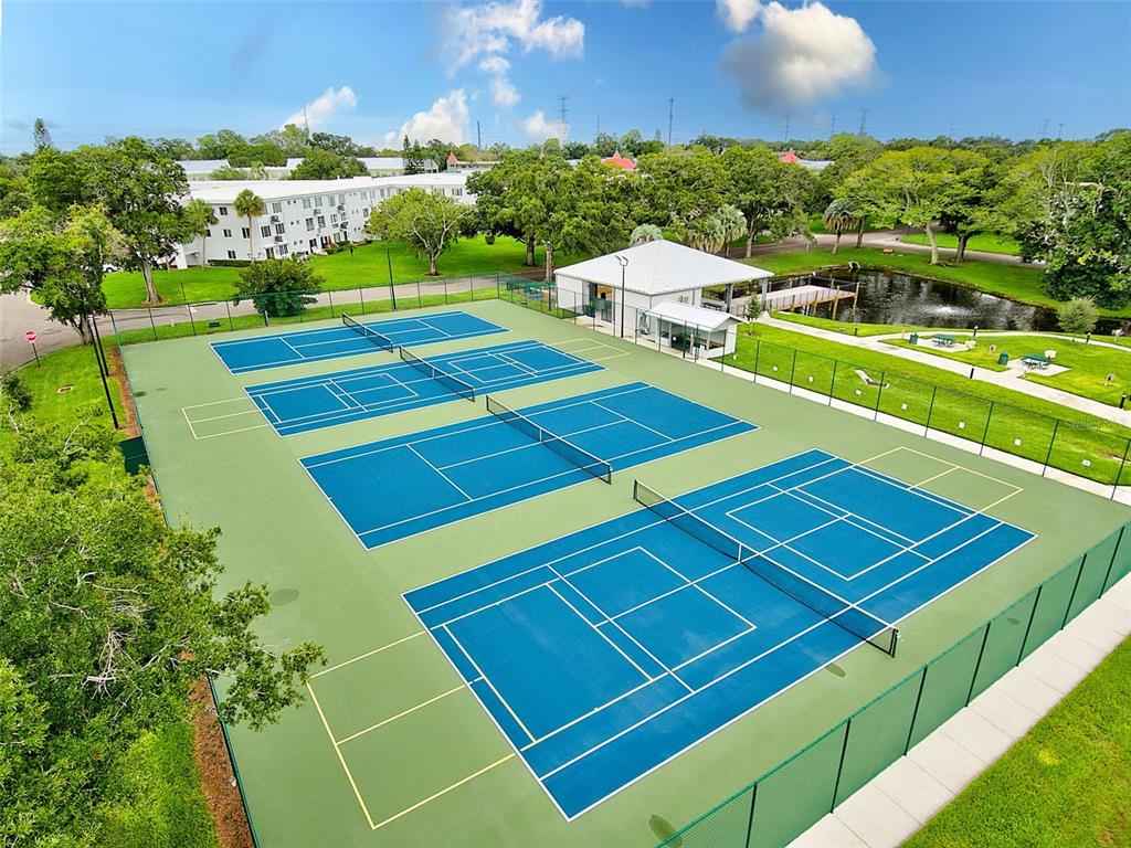 2461 Rhodesian Drive, Unit 19 Clearwater, FL 33763 - Photo 25 of 28 a view of a tennis ground with large trees