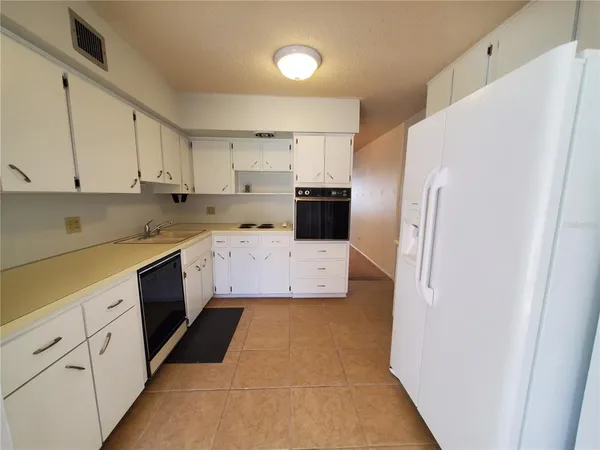 a kitchen with stainless steel appliances a refrigerator sink and cabinets