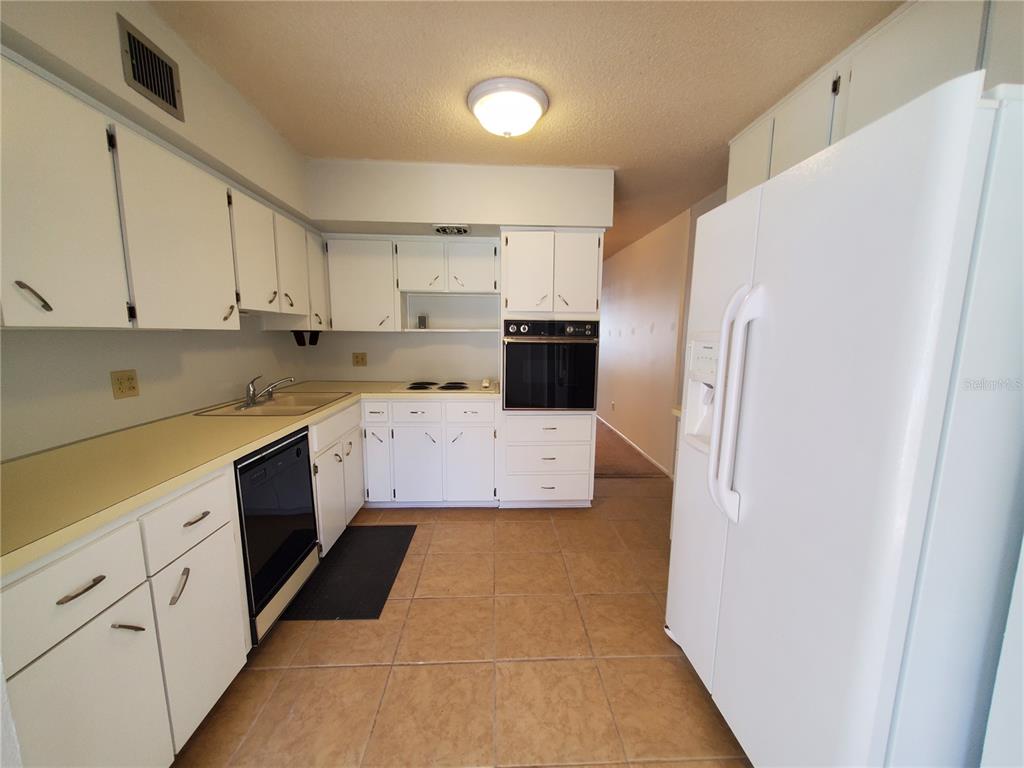 2461 Rhodesian Drive, Unit 19 Clearwater, FL 33763 - Photo 7 of 28 a kitchen with stainless steel appliances a refrigerator sink and cabinets