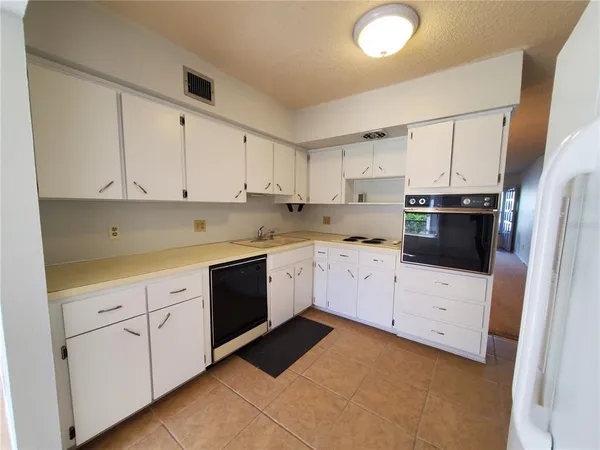 a kitchen with granite countertop white cabinets and white appliances