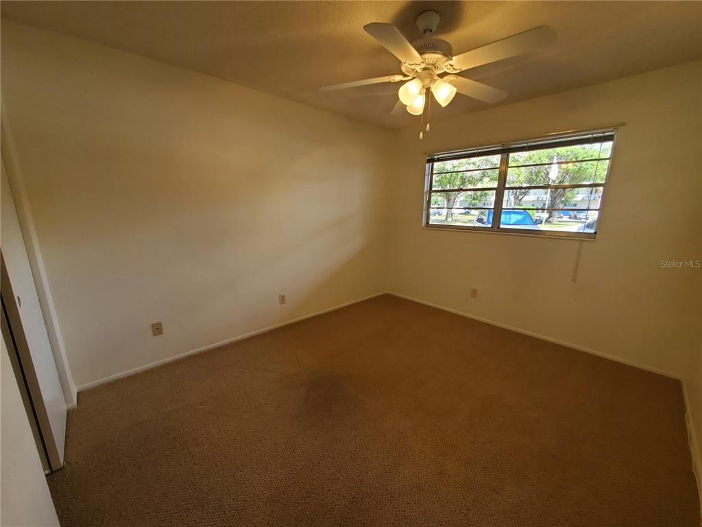 2461 Rhodesian Drive, Unit 19 Clearwater, FL 33763 - Photo 9 of 28 an empty room with windows and fan