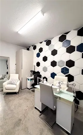 a living room with a black white checkered floor with couches and a dining table with wooden cabinet