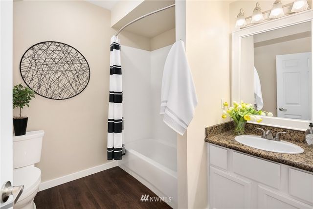 a bathroom with a granite countertop sink a mirror and vanity