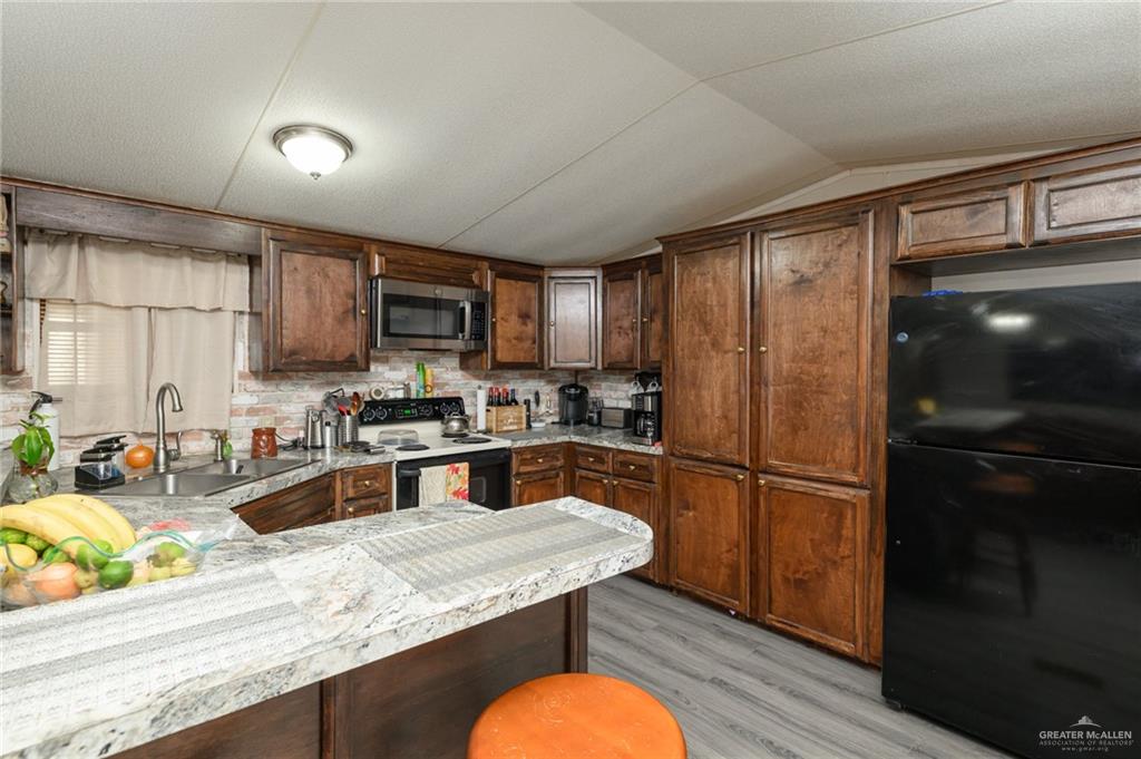 36338 Marshall Hutts Road Rio Hondo, TX 78583 - Photo 11 of 42 a kitchen with granite countertop stainless steel appliances and wooden cabinets