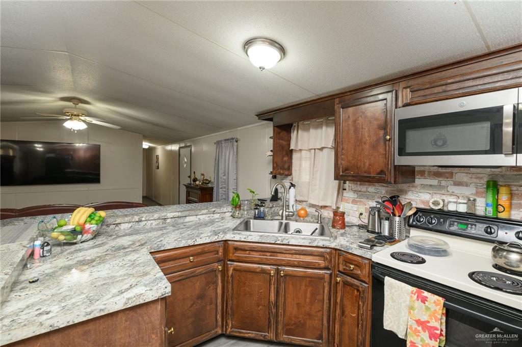 36338 Marshall Hutts Road Rio Hondo, TX 78583 - Photo 12 of 42 a kitchen with stainless steel appliances granite countertop a sink stove and microwave