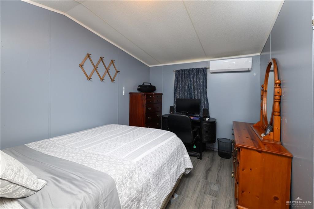 36338 Marshall Hutts Road Rio Hondo, TX 78583 - Photo 19 of 42 a bedroom with a bed and wooden floor