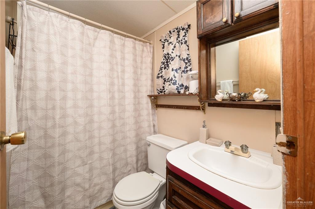 36338 Marshall Hutts Road Rio Hondo, TX 78583 - Photo 24 of 42 a bathroom with a sink a toilet and a mirror