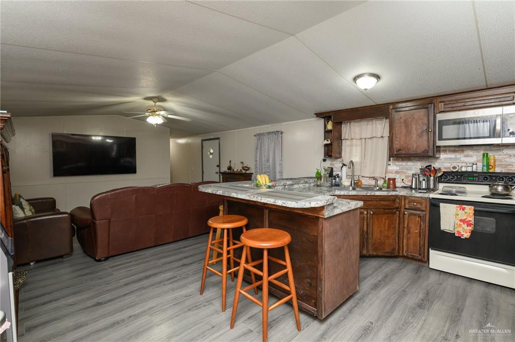 36338 Marshall Hutts Road Rio Hondo, TX 78583 - Photo 9 of 42 a kitchen with stainless steel appliances granite countertop a stove and a wooden floors