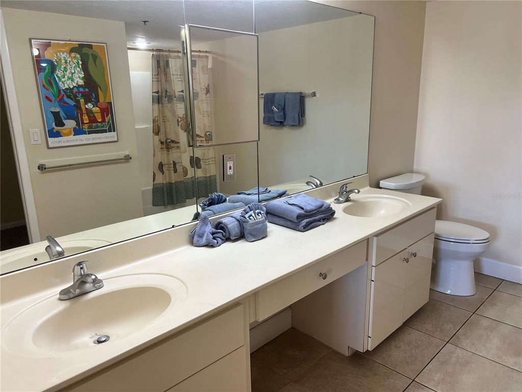 1001 Point Of Rocks Road, Unit 309 Sarasota, FL 34242 - Photo 14 of 38 a bathroom with a sink double vanity and a toilet