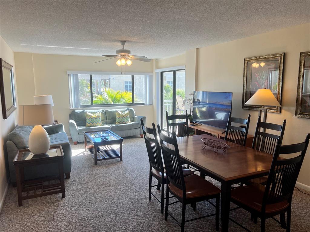 1001 Point Of Rocks Road, Unit 309 Sarasota, FL 34242 - Photo 6 of 38 a dining room with furniture a rug and a chandelier