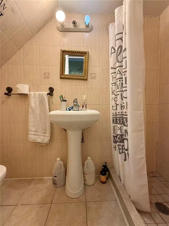 1876 Bay Ridge Avenue Brooklyn, NY 11204 - Photo 5 of 12 a bathroom with a sink a mirror and shower curtain