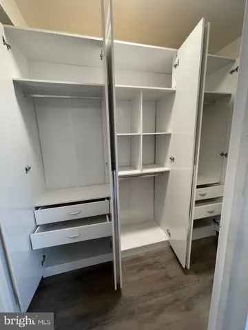 a view of walk in closet with empty racks