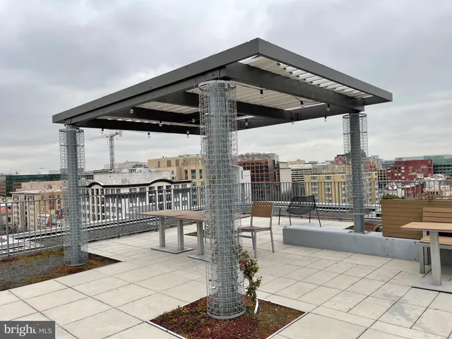 a roof deck view with a bench and potted plants