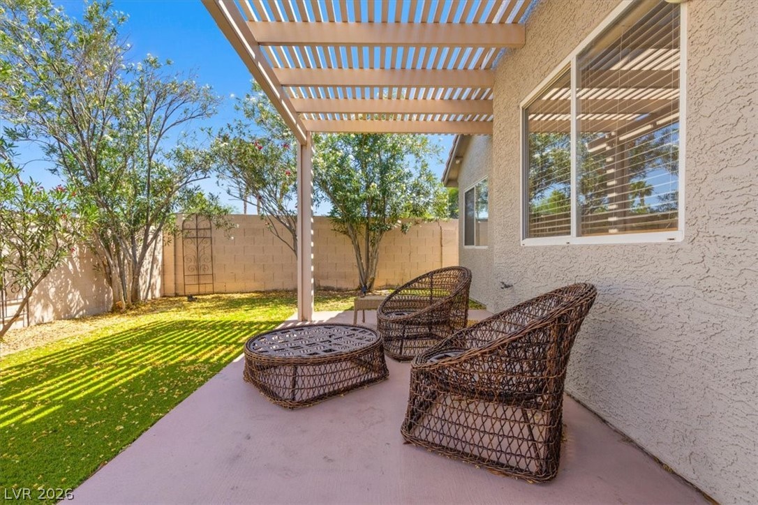 2377 Ramsgate Drive Henderson, NV 89074 - Photo 4 of 25 A tranquil outdoor living space, featuring a covered patio and a manicured artificial lawn, perfect for relaxation.