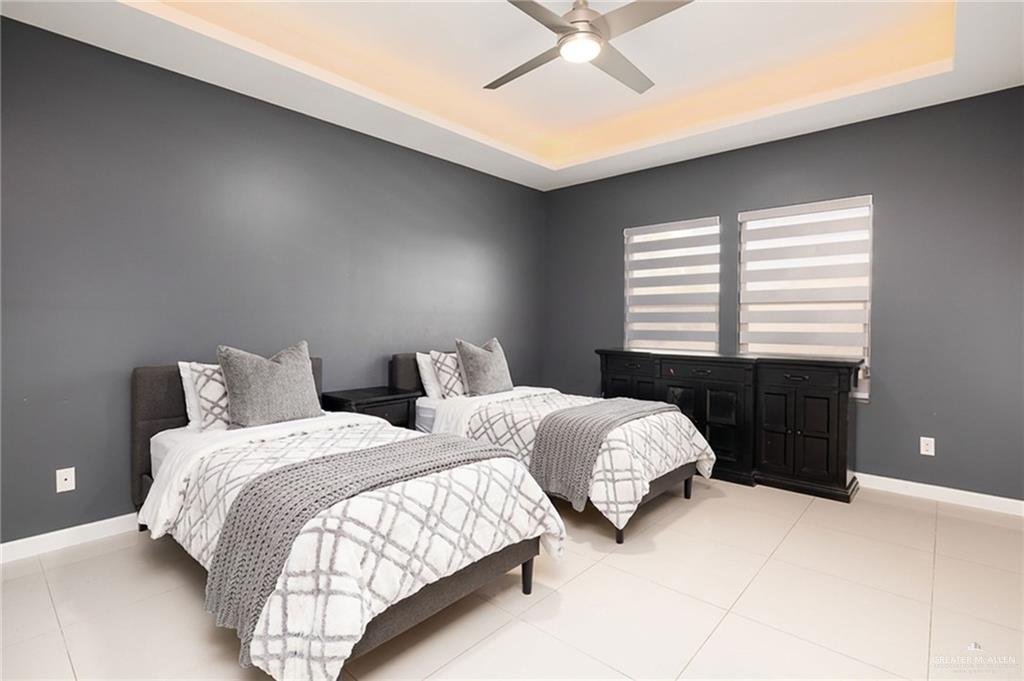 1014 Hill Country Road Edinburg, TX 78539 - Photo 19 of 31 a bedroom with two beds and a chandelier