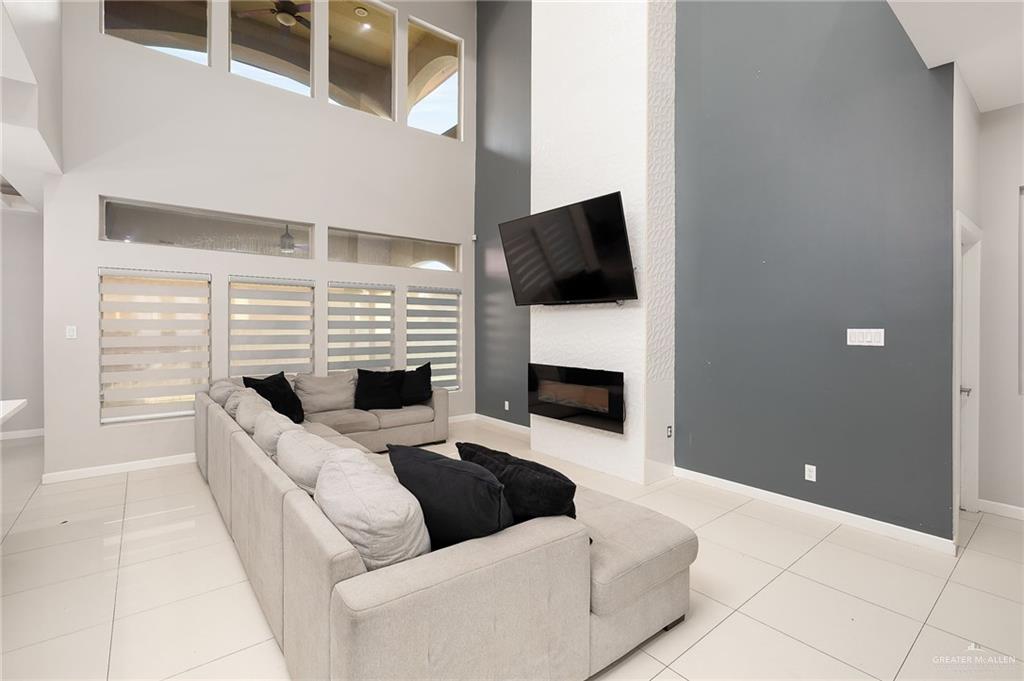 1014 Hill Country Road Edinburg, TX 78539 - Photo 4 of 31 a living room with furniture a fireplace and a flat screen tv