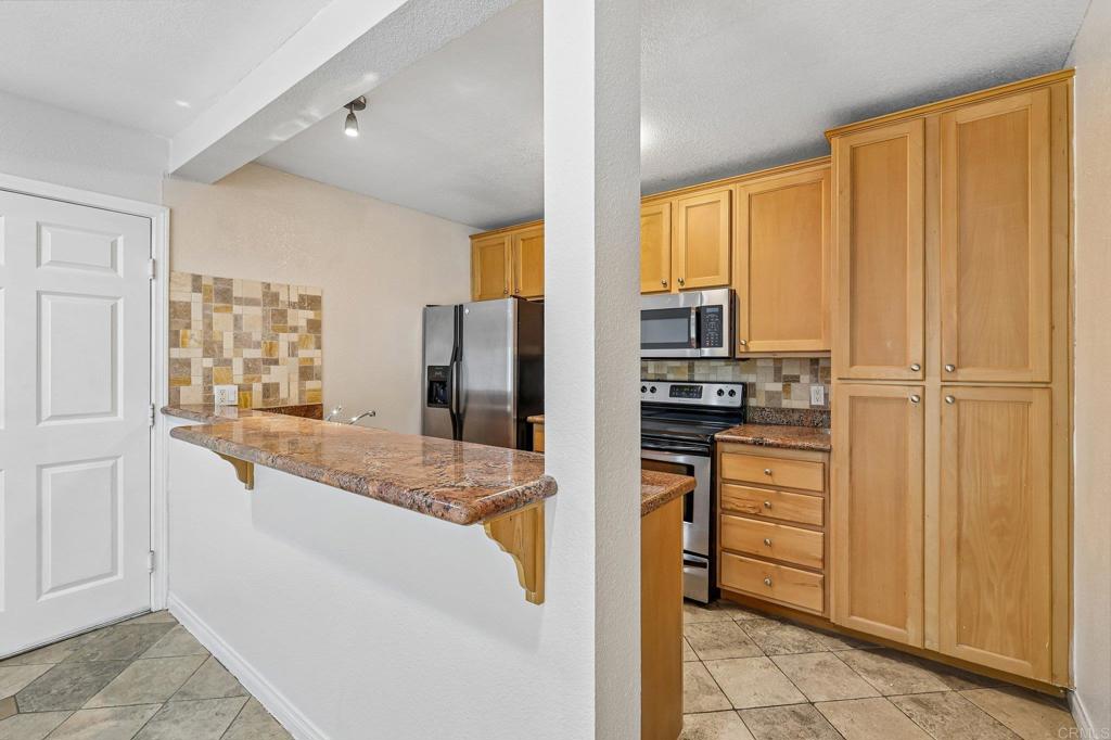 9860 Dale Avenue, Unit A3 Spring Valley, CA 91977 - Photo 1 of 1 a large kitchen with kitchen island granite countertop a refrigerator and cabinets