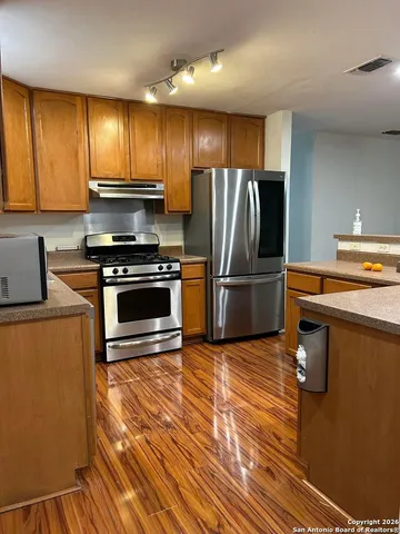 a kitchen with granite countertop a refrigerator stove and microwave