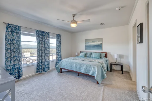 a spacious bedroom with a large bed and a chandelier