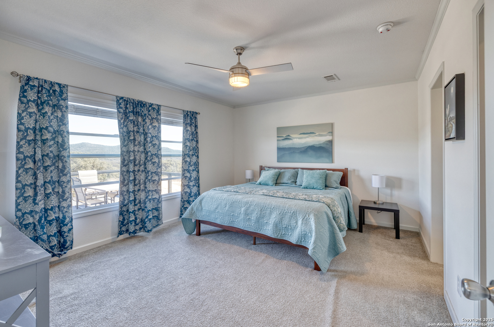 3049 North Little Creek Road Utopia, TX 78884 - Photo 14 of 38 a spacious bedroom with a large bed and a chandelier