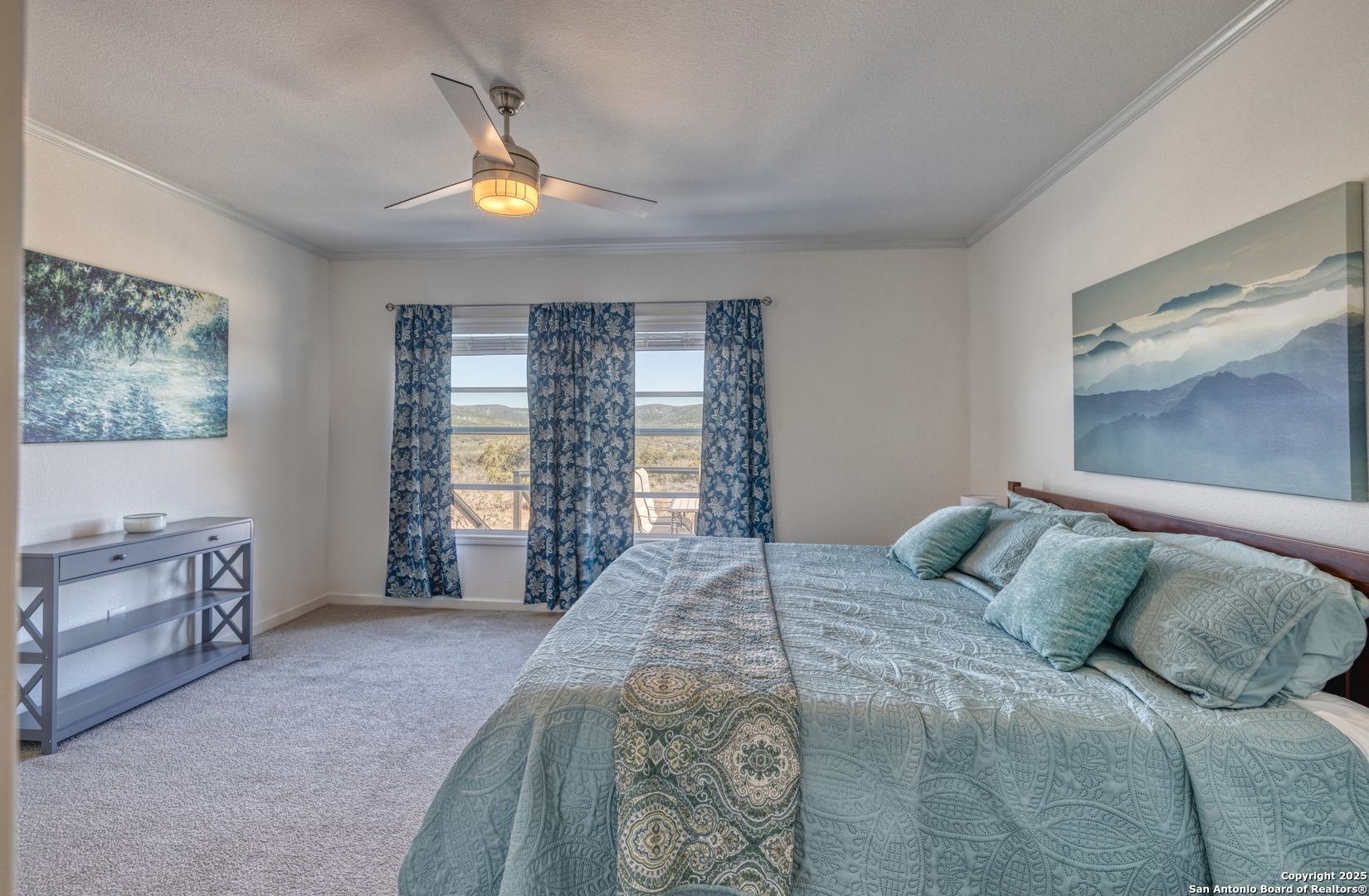 3049 North Little Creek Road Utopia, TX 78884 - Photo 15 of 38 a bedroom with a bed and a chandelier