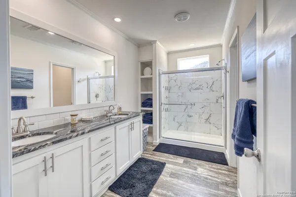 a bathroom with a granite countertop sink mirror and shower