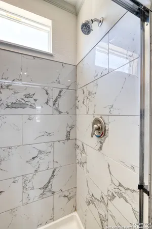 a bathroom with a granite countertop shower and sink