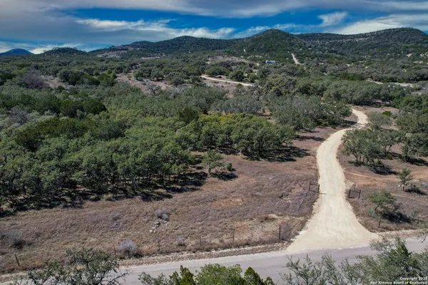 an aerial view of a house with a yard and mountain