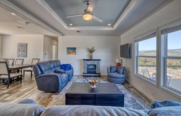 a living room with furniture a fireplace and a large window