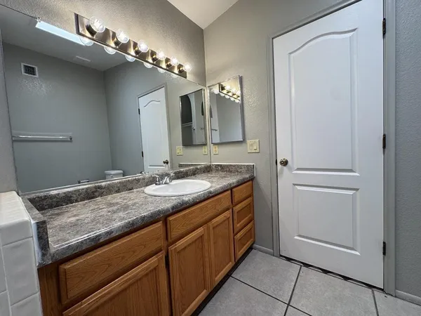 a bathroom with a granite countertop sink and a mirror