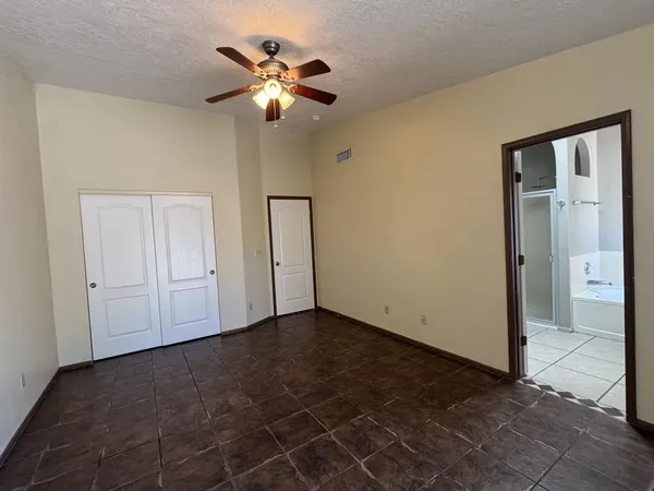 an empty room with chandelier fan