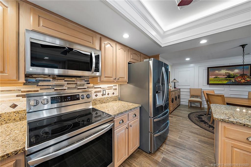 8 North River Road Stuart, FL 34996 - Photo 11 of 42 a kitchen with stainless steel appliances kitchen island granite countertop a stove and a microwave