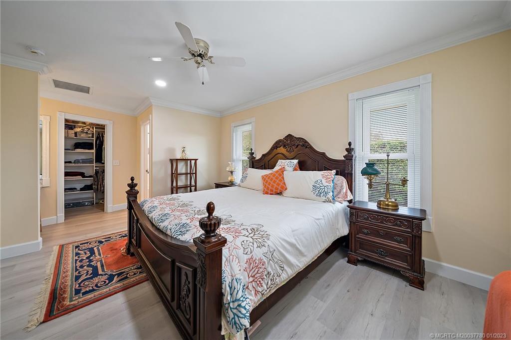 8 North River Road Stuart, FL 34996 - Photo 17 of 42 a bed sitting in a spacious bedroom next to a window and a chandelier