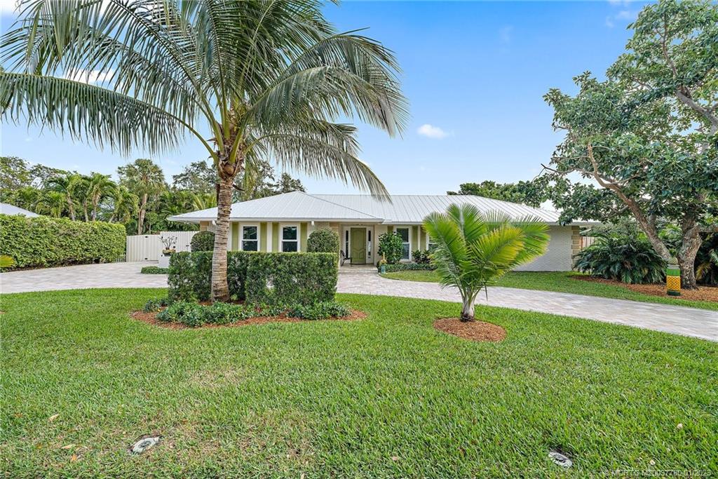 8 North River Road Stuart, FL 34996 - Photo 2 of 42 a house with palm tree in front of it