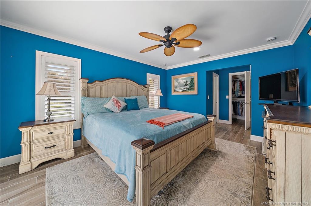 8 North River Road Stuart, FL 34996 - Photo 23 of 42 a bedroom with a large bed and a chandelier