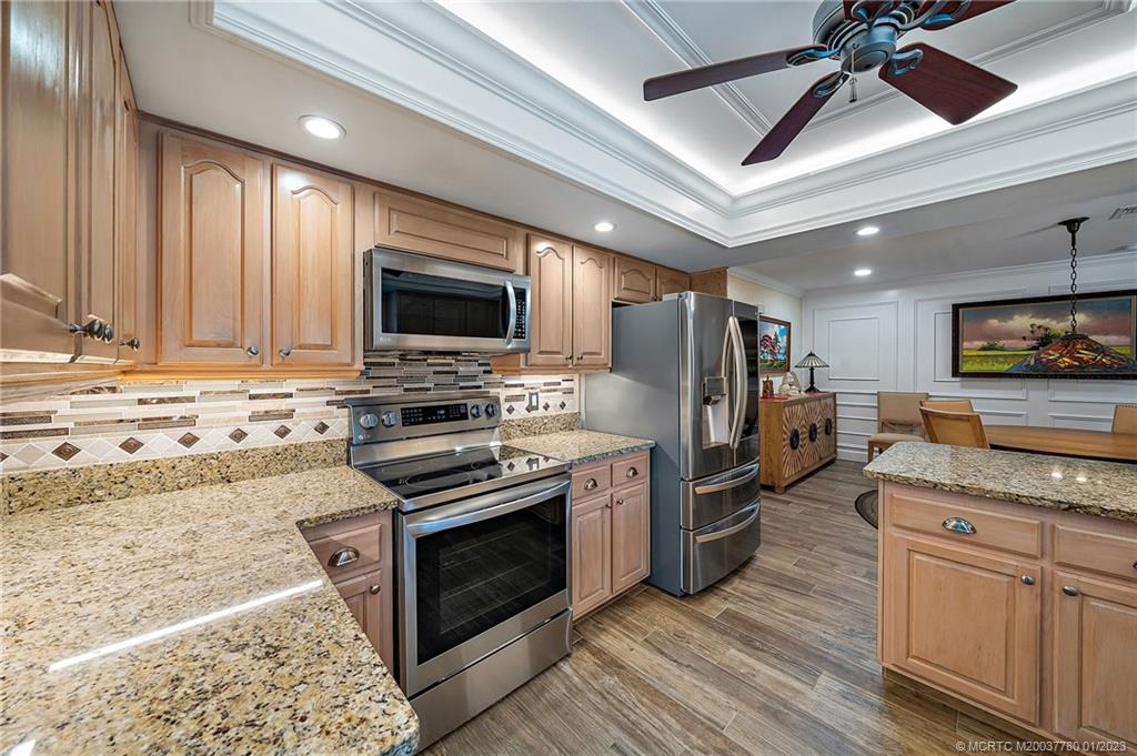 8 North River Road Stuart, FL 34996 - Photo 10 of 42 a kitchen with granite countertop a refrigerator stove and microwave