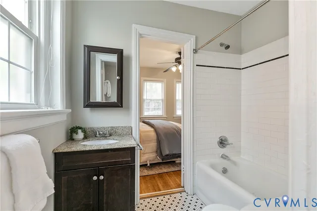 a bathroom with a tub sink and mirror