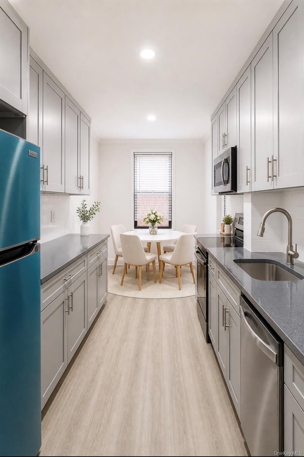 150-11 72nd Road, Unit 4 Queens, NY 11367 - Photo 5 of 12 a large white kitchen with stainless steel appliances granite countertop lots of white cabinets a sink and dishwasher a stove with wooden floor