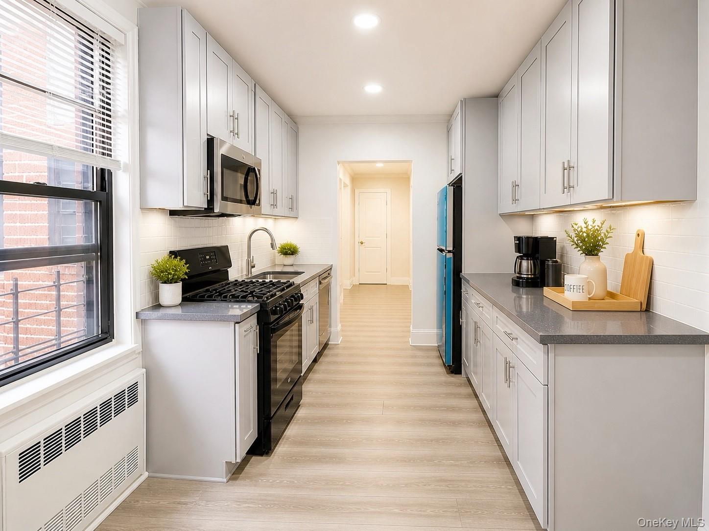 150-11 72nd Road, Unit 4 Queens, NY 11367 - Photo 9 of 12 a kitchen with stainless steel appliances granite countertop a stove a sink and a refrigerator