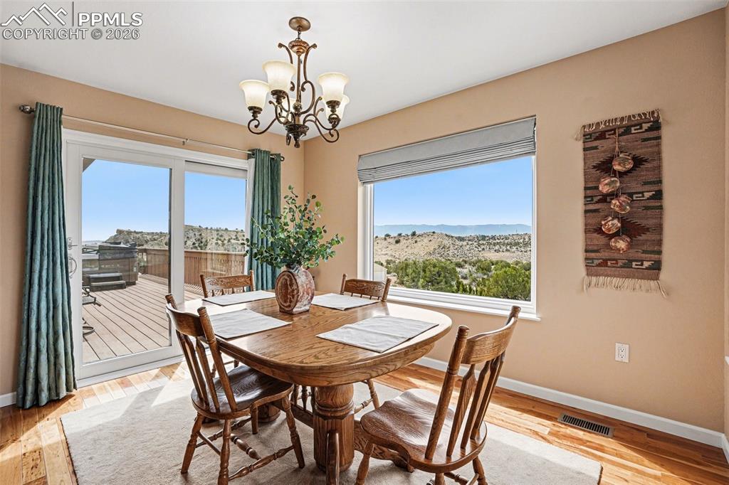 459 Bowie Road Penrose, CO 81240 - Photo 11 of 47 The dining area features an open layout with easy flow from the living room and kitchen. It walks out to a Trex deck with a relaxing hot tub, making it ideal for indoor-outdoor entertaining.
