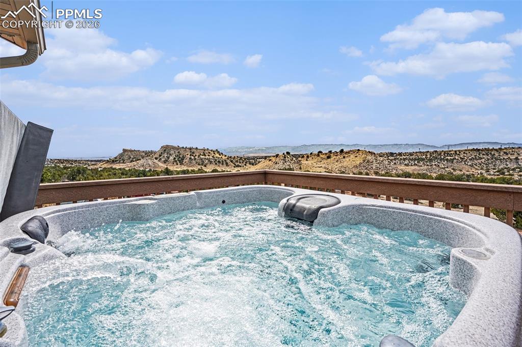 459 Bowie Road Penrose, CO 81240 - Photo 32 of 47 The upstairs Trex deck is perfect for relaxation and entertaining, featuring a hot tub and stunning views of the mountains and surrounding open space. This outdoor space seamlessly connects to the dining area, offering an ideal spot to enjoy Colorado evenings and outdoor living.