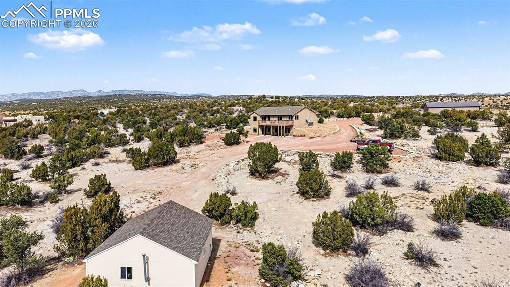 459 Bowie Road Penrose, CO 81240 - Photo 40 of 47 From an aerial perspective, the nearly 40-acre property showcases the custom stucco ranch home, attached 2-car garage, and detached heated shop, all surrounded by wide-open land. The layout highlights panoramic mountain and open-space views, equestrian-friendly acreage, and the peaceful Colorado country setting.
