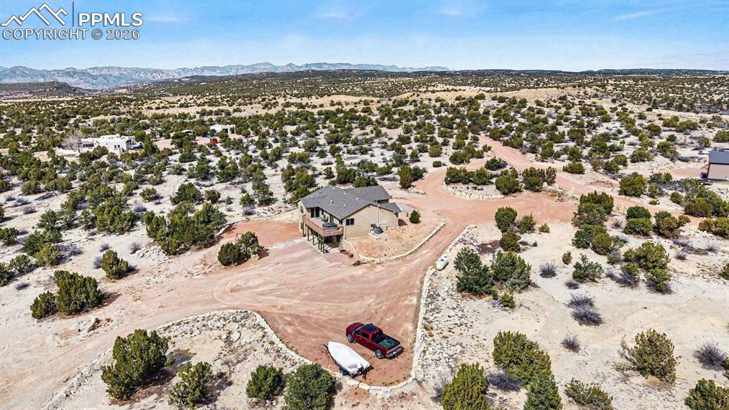 459 Bowie Road Penrose, CO 81240 - Photo 43 of 47 From an aerial perspective, the nearly 40-acre property showcases the custom stucco ranch home, attached 2-car garage, and detached heated shop, all surrounded by wide-open land. The layout highlights panoramic mountain and open-space views, equestrian-friendly acreage, and the peaceful Colorado country setting.