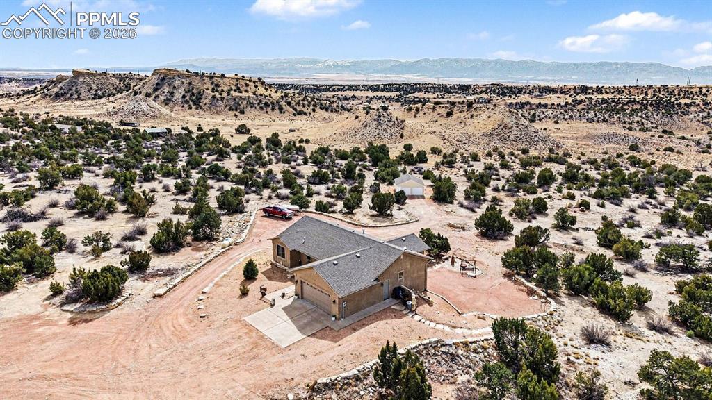 459 Bowie Road Penrose, CO 81240 - Photo 44 of 47 From an aerial perspective, the nearly 40-acre property showcases the custom stucco ranch home, attached 2-car garage, and detached heated shop, all surrounded by wide-open land. The layout highlights panoramic mountain and open-space views, equestrian-friendly acreage, and the peaceful Colorado country setting.