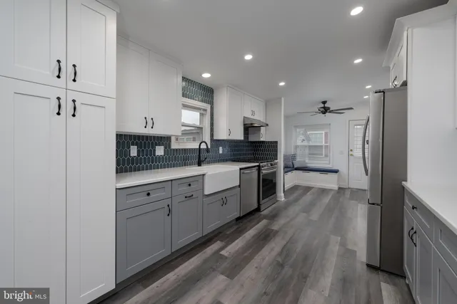 a large kitchen with stainless steel appliances and white cabinets